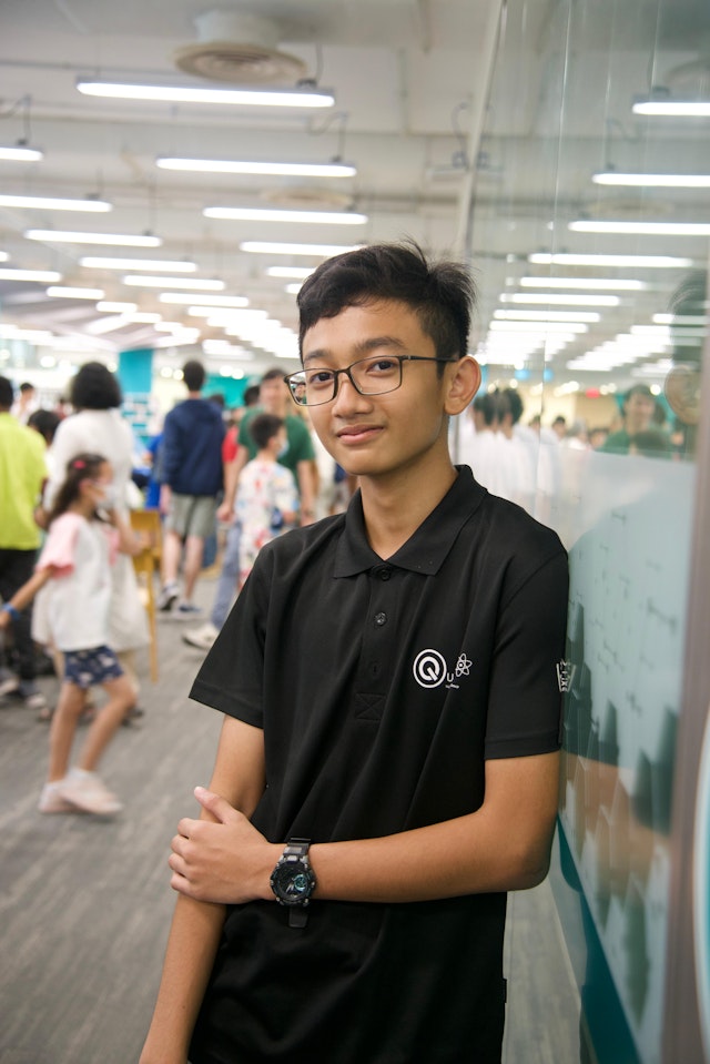 Image of Ahmad Dzuizz Annajib wearing NUS High School's very own Physics Interest Group (Quanta) shirt when helping out during NUS High School Open House 2024